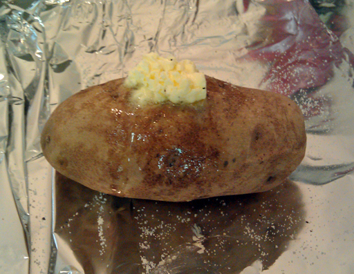 Spoon full of butter on potato